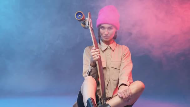 Encantadora hipster femenina posa con patín en un estudio de ahumado — Vídeos de Stock