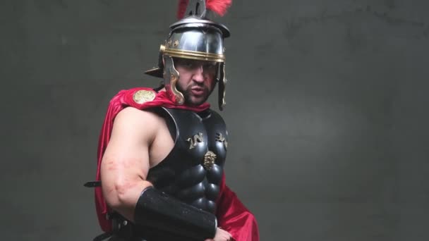 Zelfverzekerde Romeinse soldaat richt zijn zwaard naar camera starend naar camera — Stockvideo