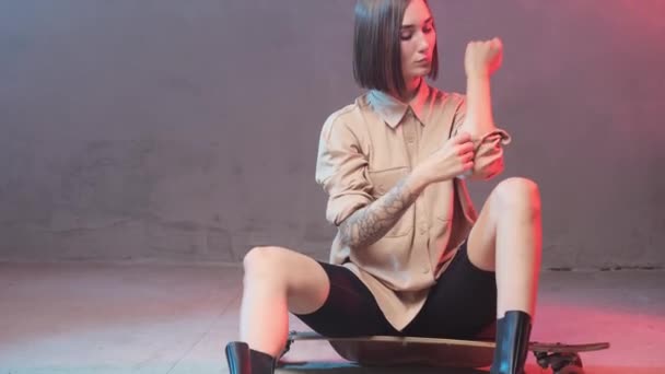 Divatos női hipster gördeszkával pózol a stúdióban — Stock videók