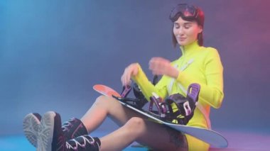 Neşeli sporcu kadın mavi arka planda gözlüğünü çıkarıyor.