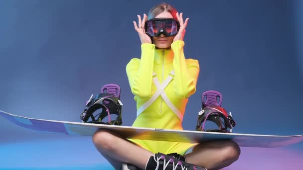 Glamour-Sportlerin mit Snowboard legt Schutzbrille ab