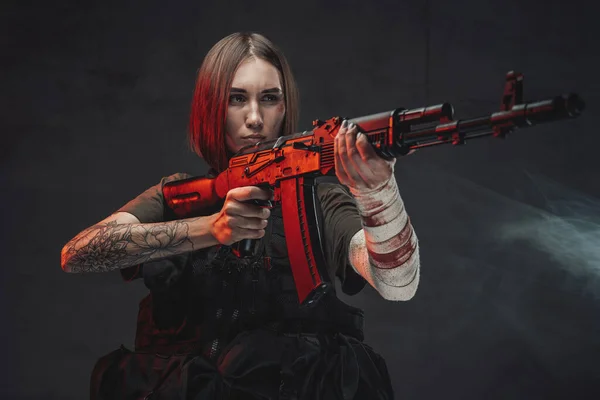 Mujer marcial apuntando con rifle en fondo oscuro y ahumado —  Fotos de Stock