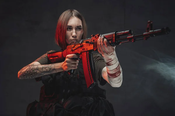 Mujer marcial apuntando con rifle en fondo oscuro y ahumado — Foto de Stock