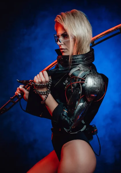 Giovane e attraente donna con la spada posa in sfondo scuro — Foto Stock