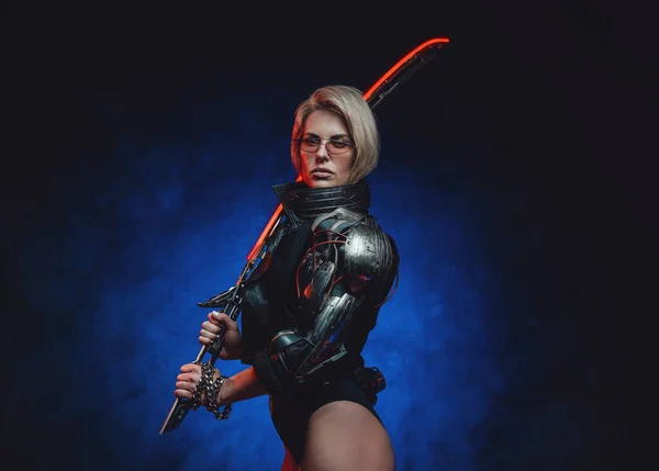 Espion femelle du futur armé d'une épée dans un fond sombre — Photo
