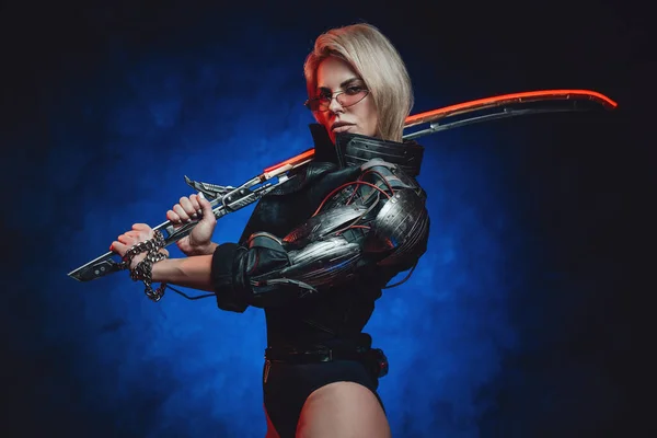 Futuristic woman with cybernetic hand and sword in dark background — Stock Photo, Image