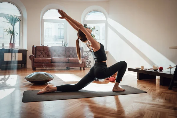 Mulher esportiva fazendo ioga em Virabhadrasana posar em casa — Fotografia de Stock