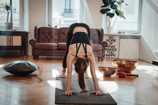 Mujer delgada caucásica haciendo ejercicio en la sala de estar con rayos de sol — Foto de Stock