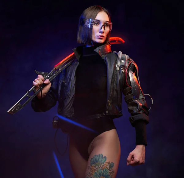 Városi és cyberpunk stílusú nő bérgyilkos karddal pózol a stúdióban — Stock Fotó