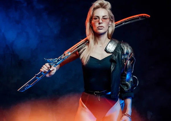 Женщина-модель в стиле киберпанк с мечом в студии — стоковое фото