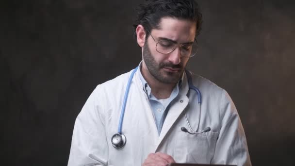 Médecin barbu en manteau blanc tapant sur comprimé — Video