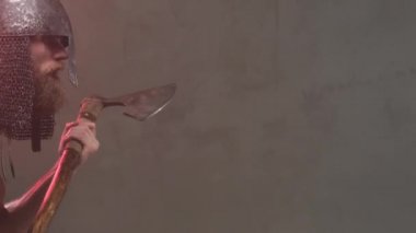 Savaşçı Viking elinde baltayla soldan sağa gidiyor.