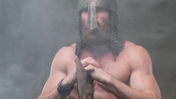 Nord guerrero sostiene hacha con sus brazos en el fondo ahumado — Vídeos de Stock