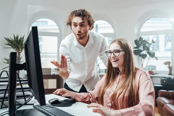 Vrouw lacht terwijl haar partner bespreken iets op het scherm — Stockfoto