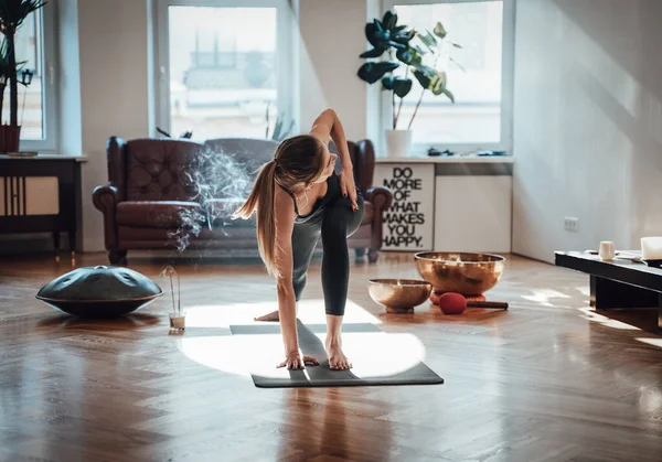 Atmosphärischer Raum mit Sonnenstrahlen und Rauch und Frau beim Yoga — Stockfoto