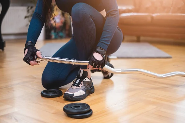 Spor kıyafetleri giymiş bir kadın salonda halter hazırlıyor. — Stok fotoğraf