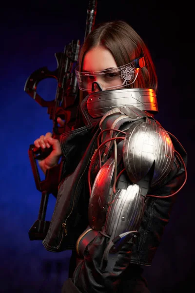 Futuristische Frau mit Brille und Gewehr vor dunkelblauem Hintergrund — Stockfoto
