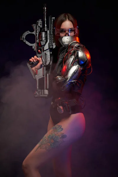 Sexy und schlanke Soldatin im Cyberpunk-Stil vor dunklem Hintergrund — Stockfoto