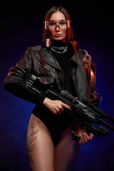 Seductive woman with naked and tattooed legs holding futuristic rifle — Stock Photo, Image