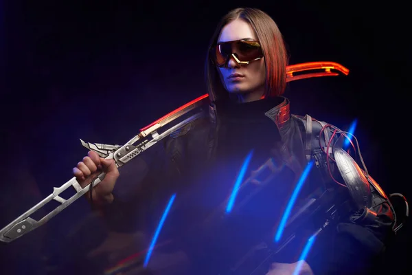 Žena vrah s mečem a puškou v barevném a tmavém pozadí — Stock fotografie