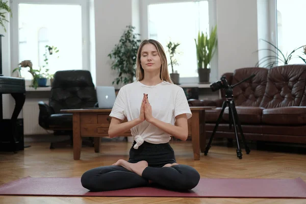 Biała kobieta uprawia jogę w spokojnej pozycji w pokoju z nowoczesnym wnętrzem — Zdjęcie stockowe