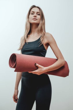 Beyaz arka planda poz veren çekici bayan sporcu