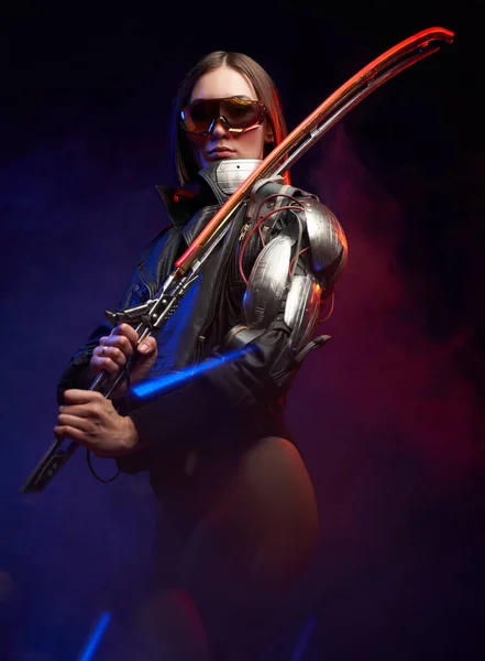Cyberzbrojna kobieta z implantem i okularami przeciwsłonecznymi trzymająca miecz — Zdjęcie stockowe