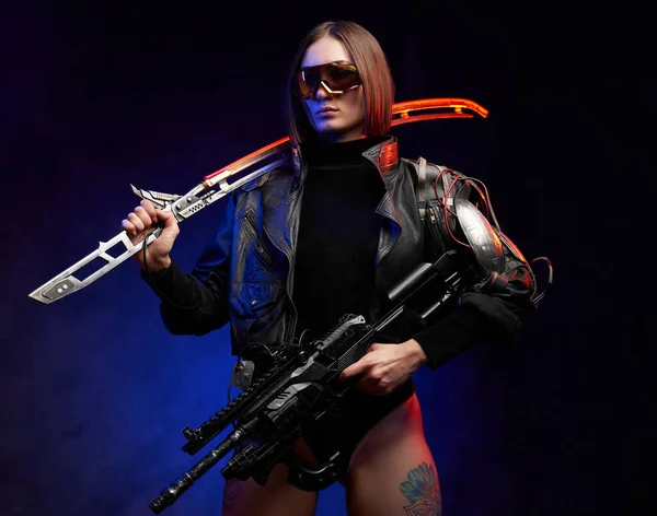 Női gyilkos karddal és puskával színes és sötét háttérrel — Stock Fotó