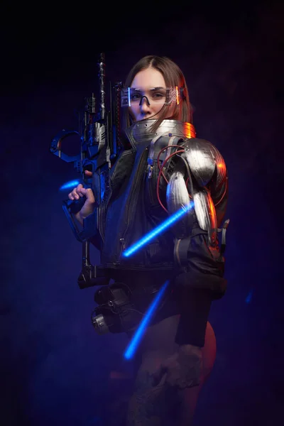 Verführerische und martialische weibliche Person mit Gewehr im dunklen Hintergrund — Stockfoto