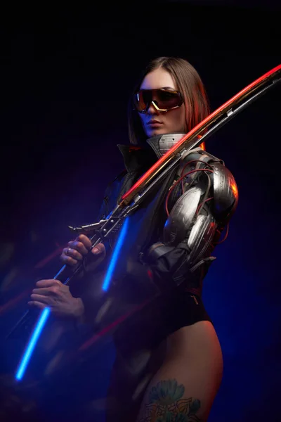 Femme soldat séduisante avec épée et main cybernétique en studio — Photo