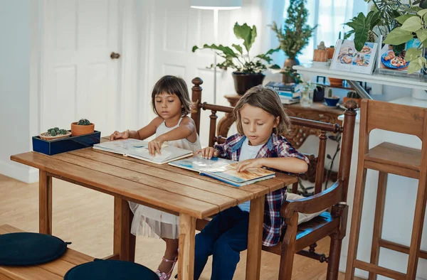Školka chlapec a dívka čtení knih u stolu v kuchyni — Stock fotografie