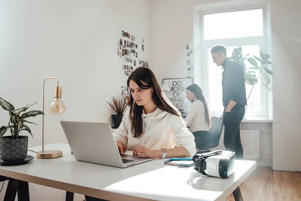 O femeie serioasă lucrează pe laptop la birou — Fotografie, imagine de stoc