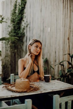 Baştan çıkarıcı kadın kahve bardağıyla caddelerdeki masada oturuyor.