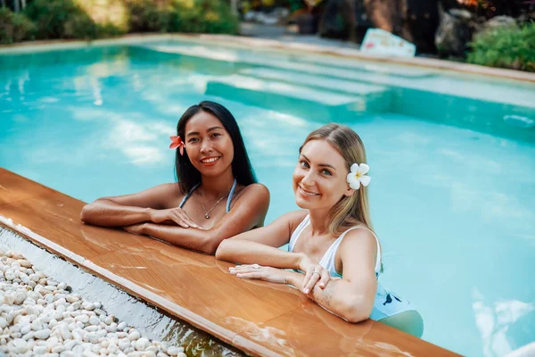 Deux femmes heureuses dans la piscine regardent caméra et sourire — Photo