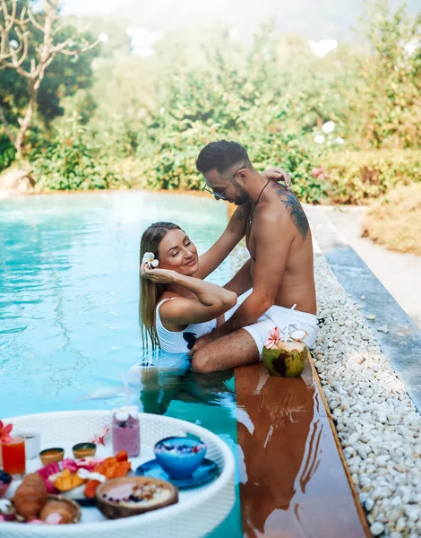 Femme souriante profite de ses vacances avec son petit ami à l'hôtel avec piscine — Photo