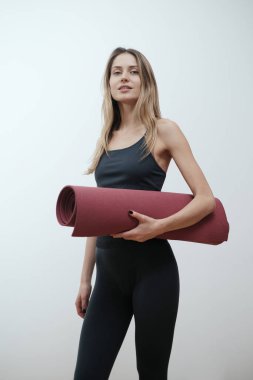 Beyaz arka planda poz veren çekici bayan sporcu