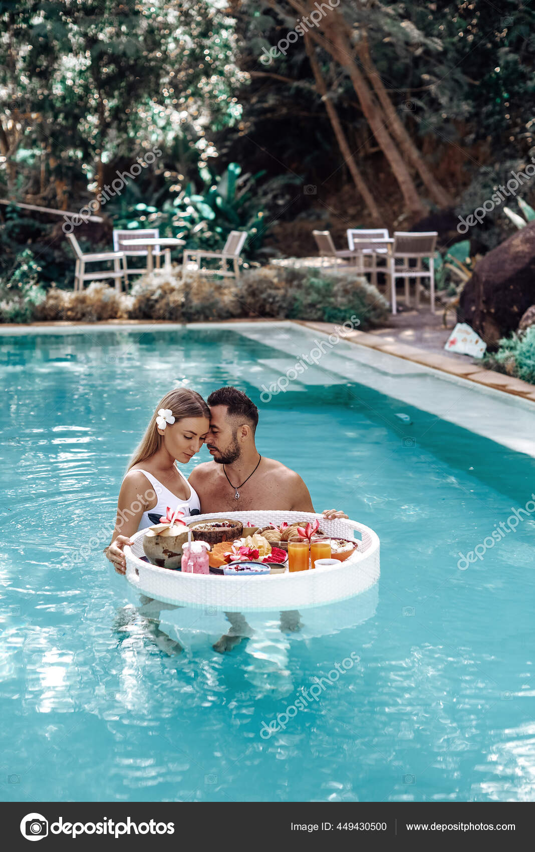 Pareja cariñosa en piscina con mesa flotante en fotografía de stock © fxquadro | Depositphotos