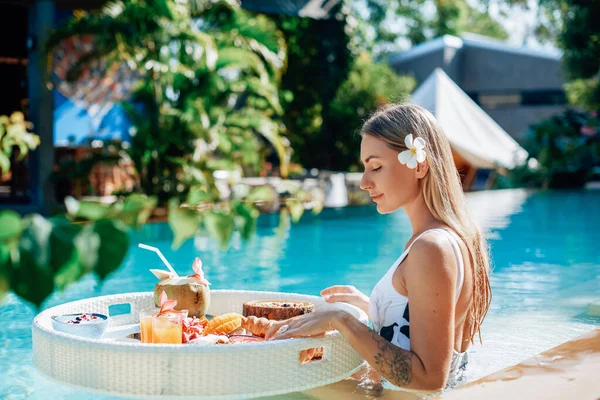 Touriste féminine dans un hôtel de luxe bénéficie de la piscine et de la nourriture tropicale — Photo