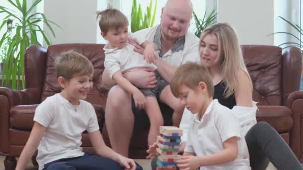 Barátságos család játszik fából készült torony és éljenzés egymást, bukó torony — Stock videók