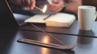  Bir adam uzaktan çalışmaya hazırlanan aromatik bir sopayı ateşe verir.