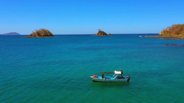 Bateau flottant sur l'eau turquoise azur clair dans la baie de la mer sur un paysage rocheux de falaise — Video