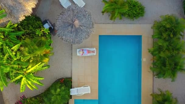 Mujer sexy en blanco tendido cerca de la piscina en villa de lujo, concepto de vacaciones tropicales — Vídeos de Stock