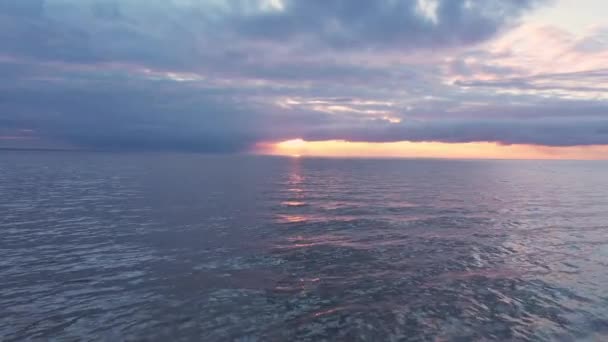 Drone vuelo hacia rosa, naranja vibrante puesta de sol en el horizonte oceánico — Vídeo de stock