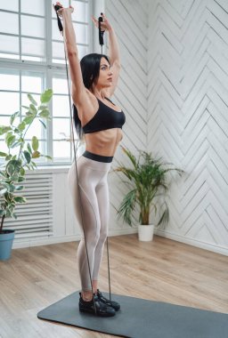 Direniş bantlarıyla sportif giyinen olgun bir sporcuyu çalıştırmak.