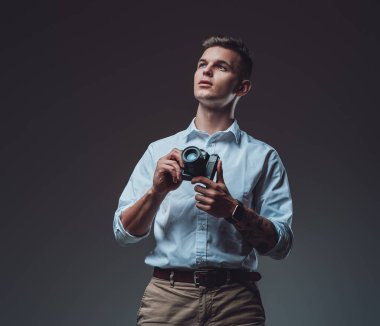 Fotoğraf makinesini tutan dalgın suratlı bir adamı kaçırıyor.
