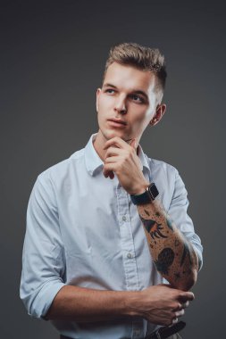 Çenesinin altında eli dövmeli başarılı bir genç adam.