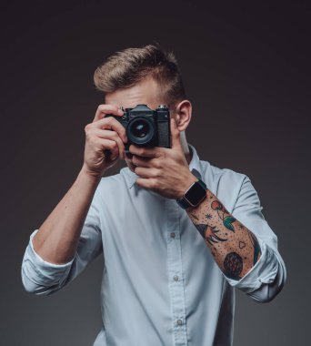 Dijital kamerasıyla çekim yapan dövmeli bir hippi.