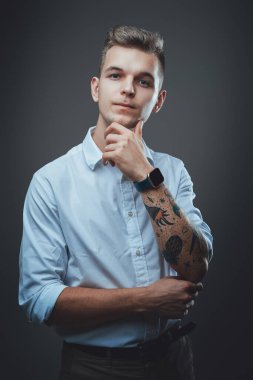 Çenesinin altında eli dövmeli başarılı bir genç adam.