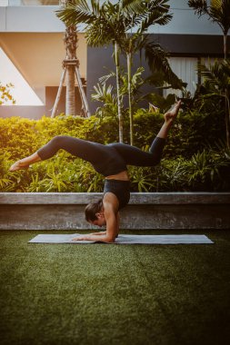 Zarif ve güçlü kadın dışarıda el üstünde çalışıyor.