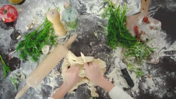 Mani da bambino che cercano di impastare l'impasto su un tavolo da taglio in cucina. — Video Stock